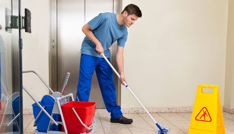 مردی در حال نظافت کف با تی