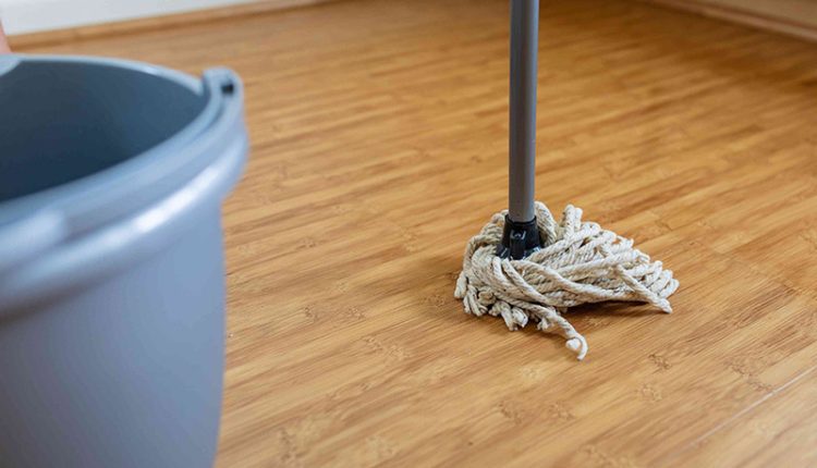 یک تی نخی در کنار سطل برای نظافت کفپوش پارکت